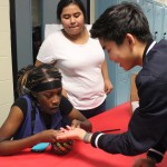 Dressed up as a palm reader, sophomore Chidinma Nnaji examines the hand of sophomore Sean Kashiwagura while sophomore Lexy Montalvo watches.